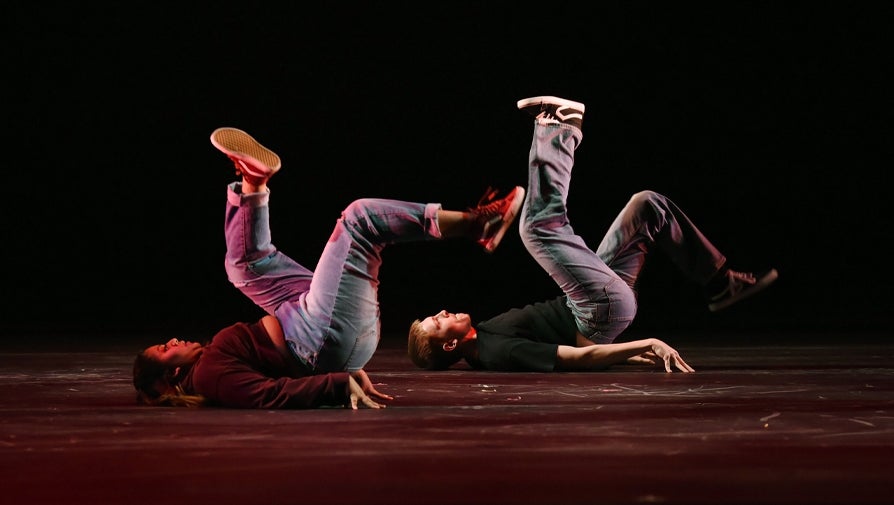 dancers lying on their backs on stage