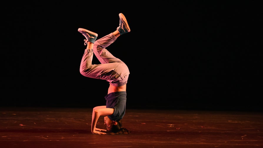 dancer on stage doing a headstand