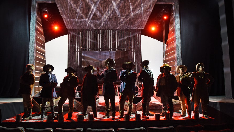 people on stage with red backlighting