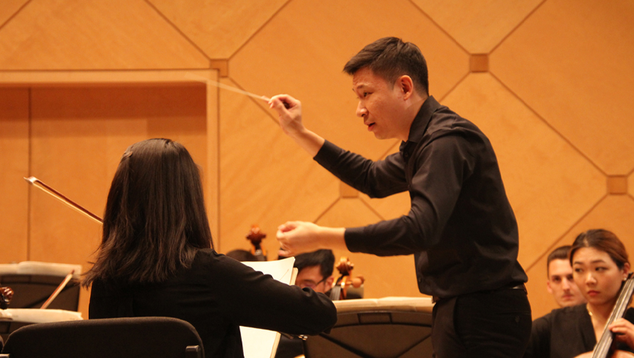 conductor conducting an orchestra performance