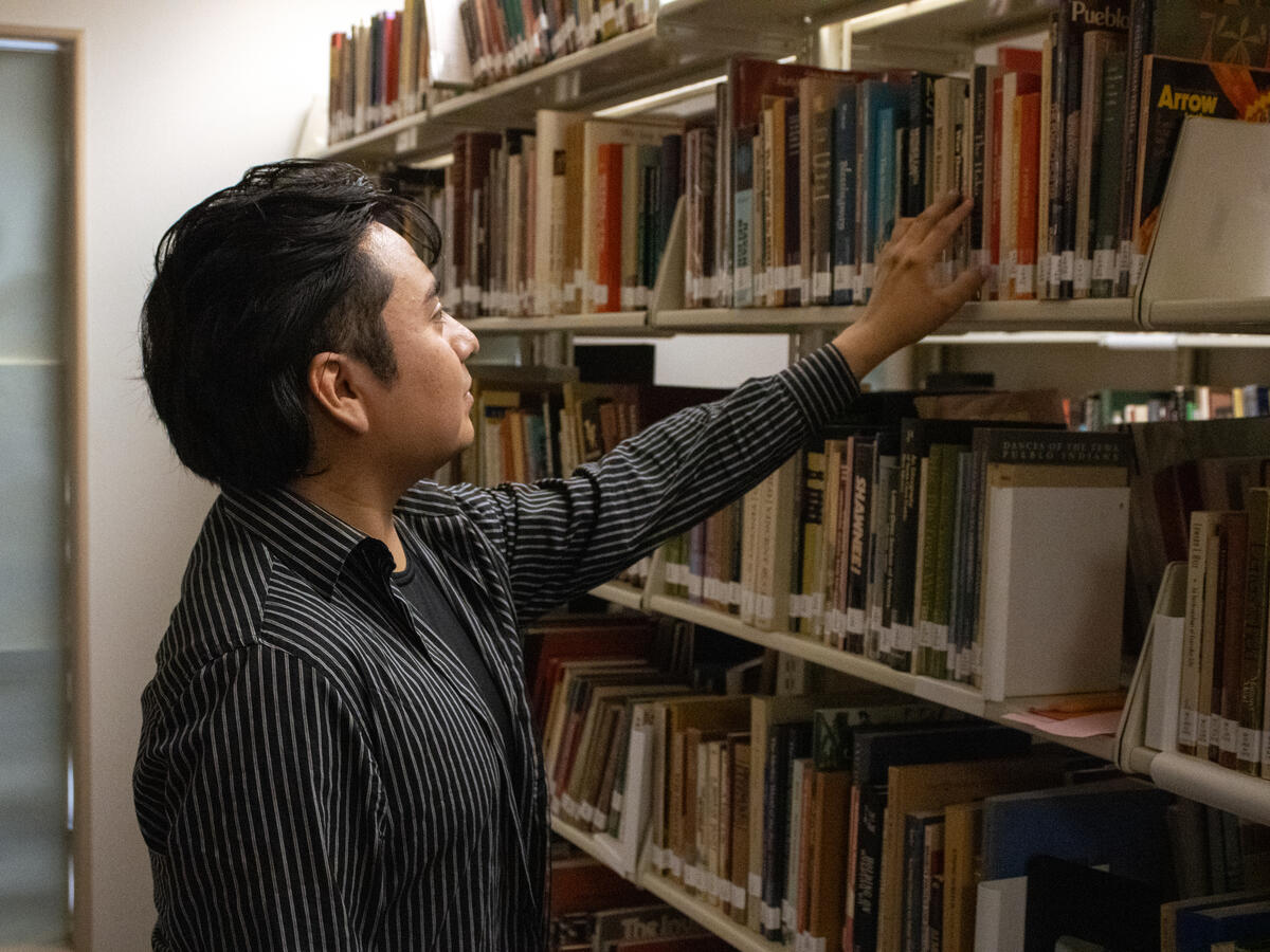 A student looks through books in the collection